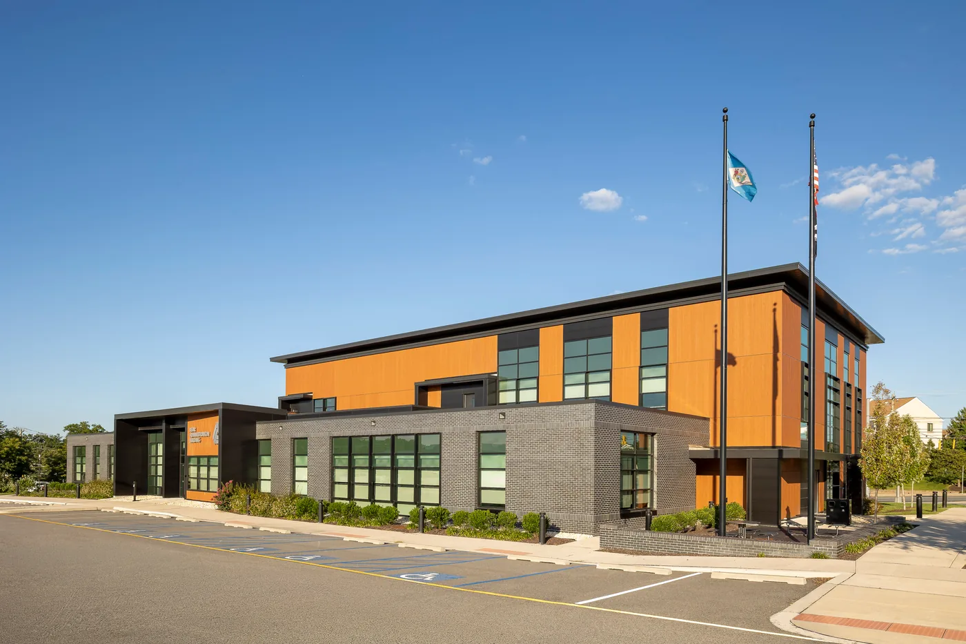 Corner view of the administration building with flags under a deep blue sky