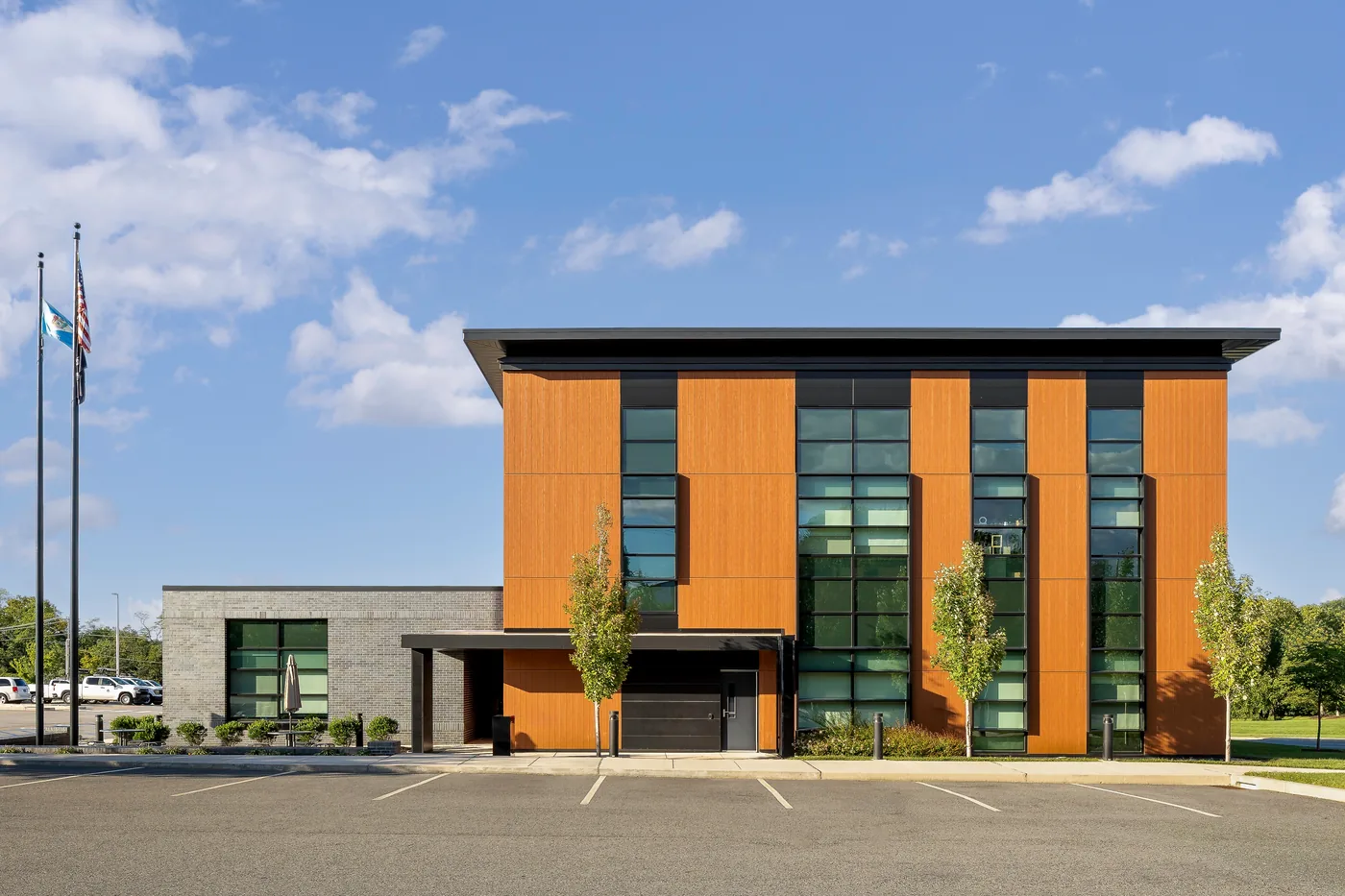 Three story elevation of warm wood look panels and tall ribbon windows