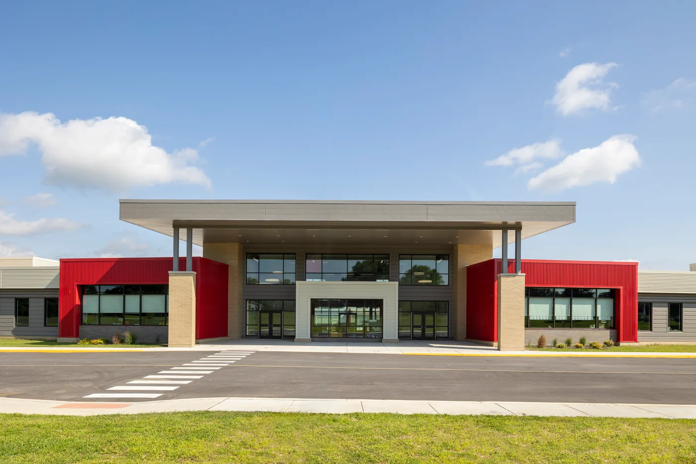 Symmetrical entry canopy of the school flanked by red corrugated cladding