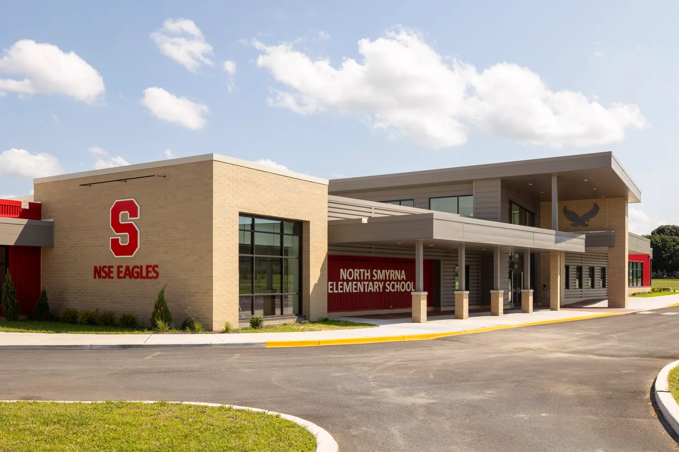Tan brick entrance with the red S and NSE Eagles lettering beside the covered walkway