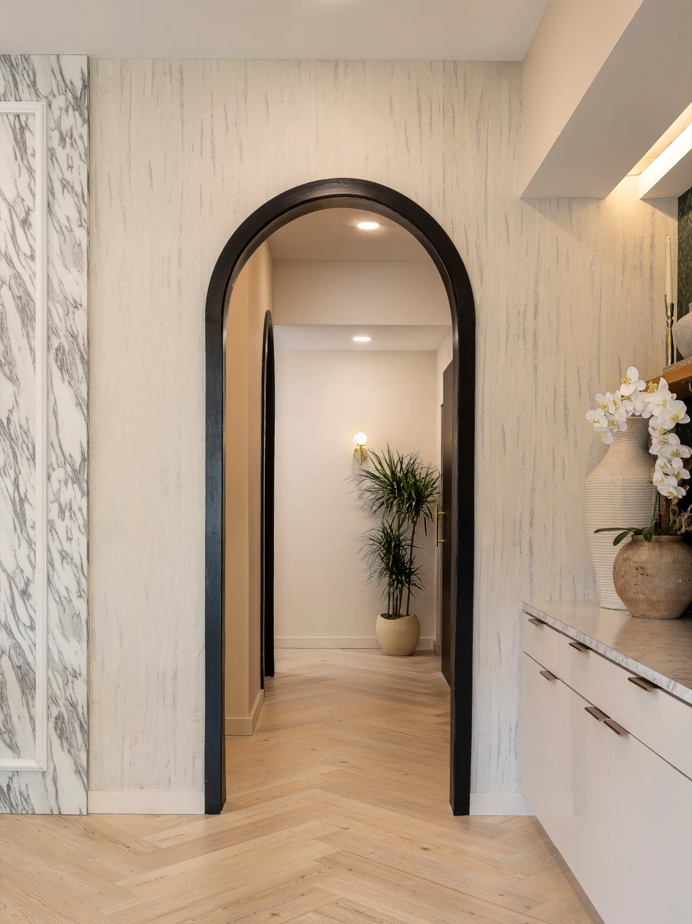 Arched doorway and herringbone floor in a spa hallway