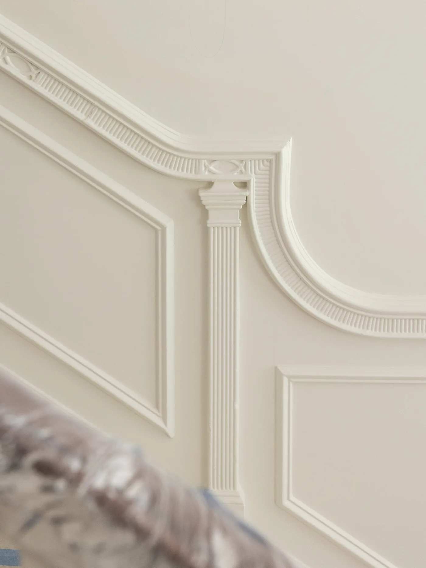 Detail of painted panel molding with a carved corner flourish