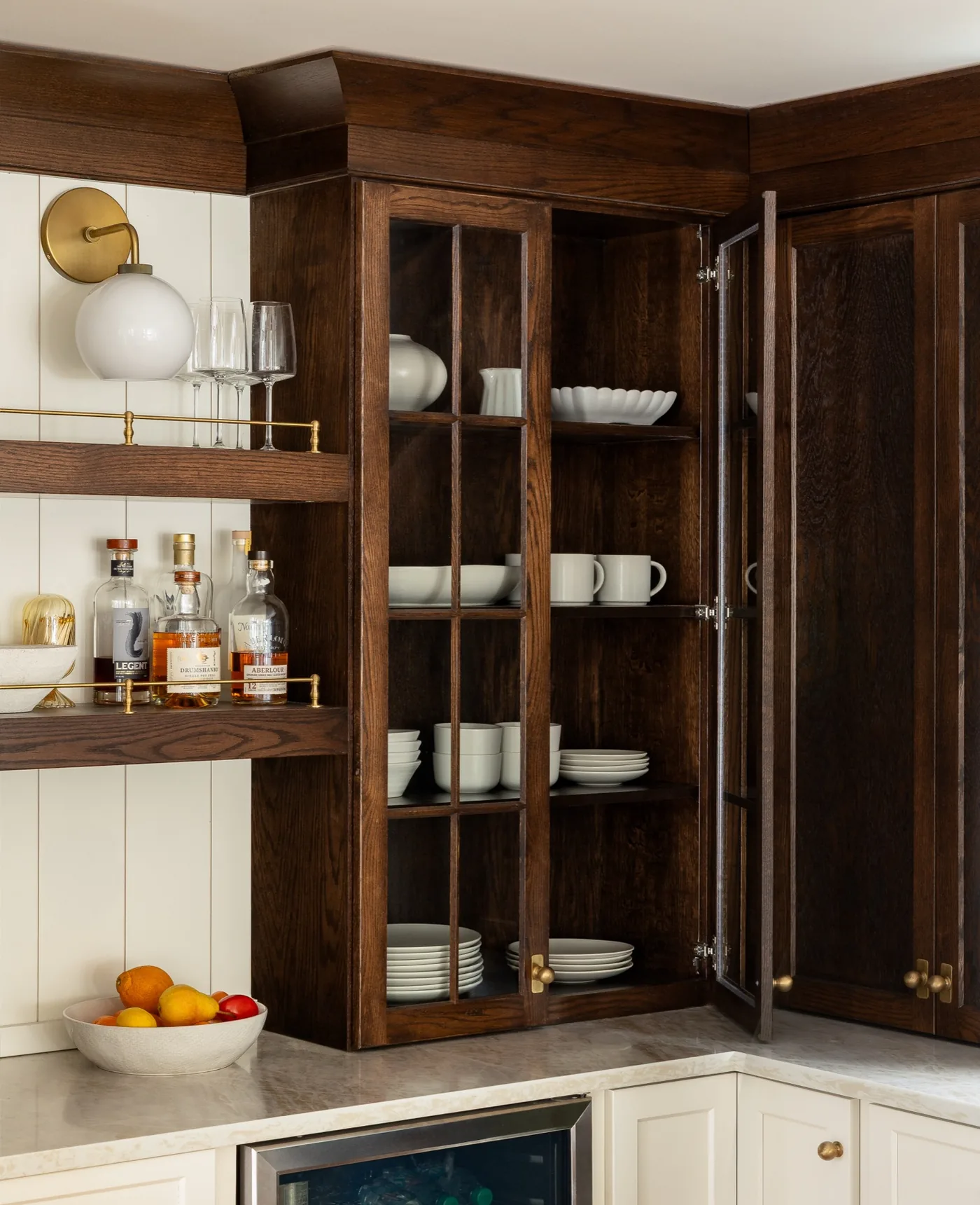 Walnut bar cabinetry with glass front uppers