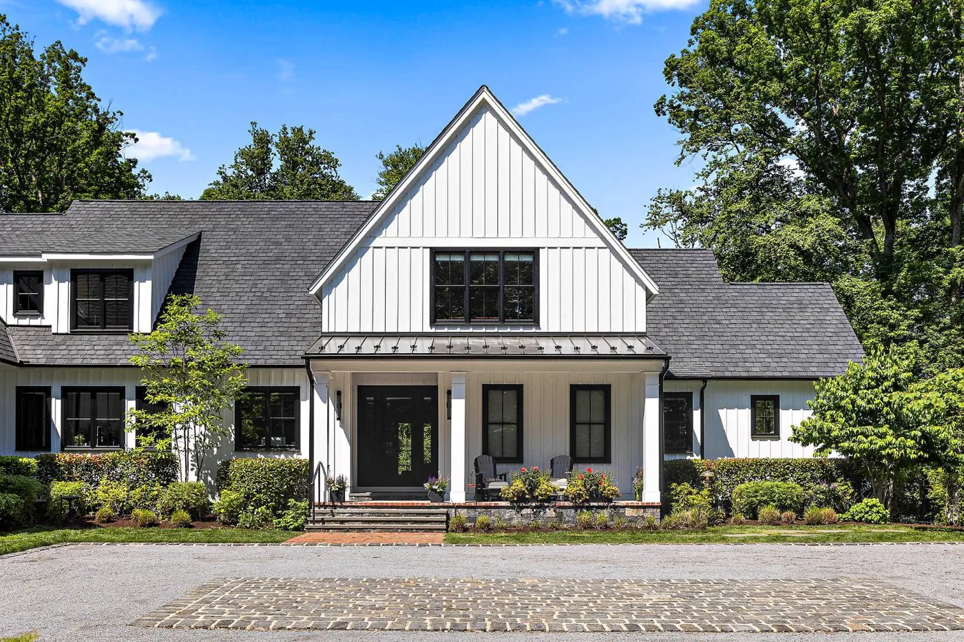 Symmetrical front gable with a standing seam porch roof and black windows