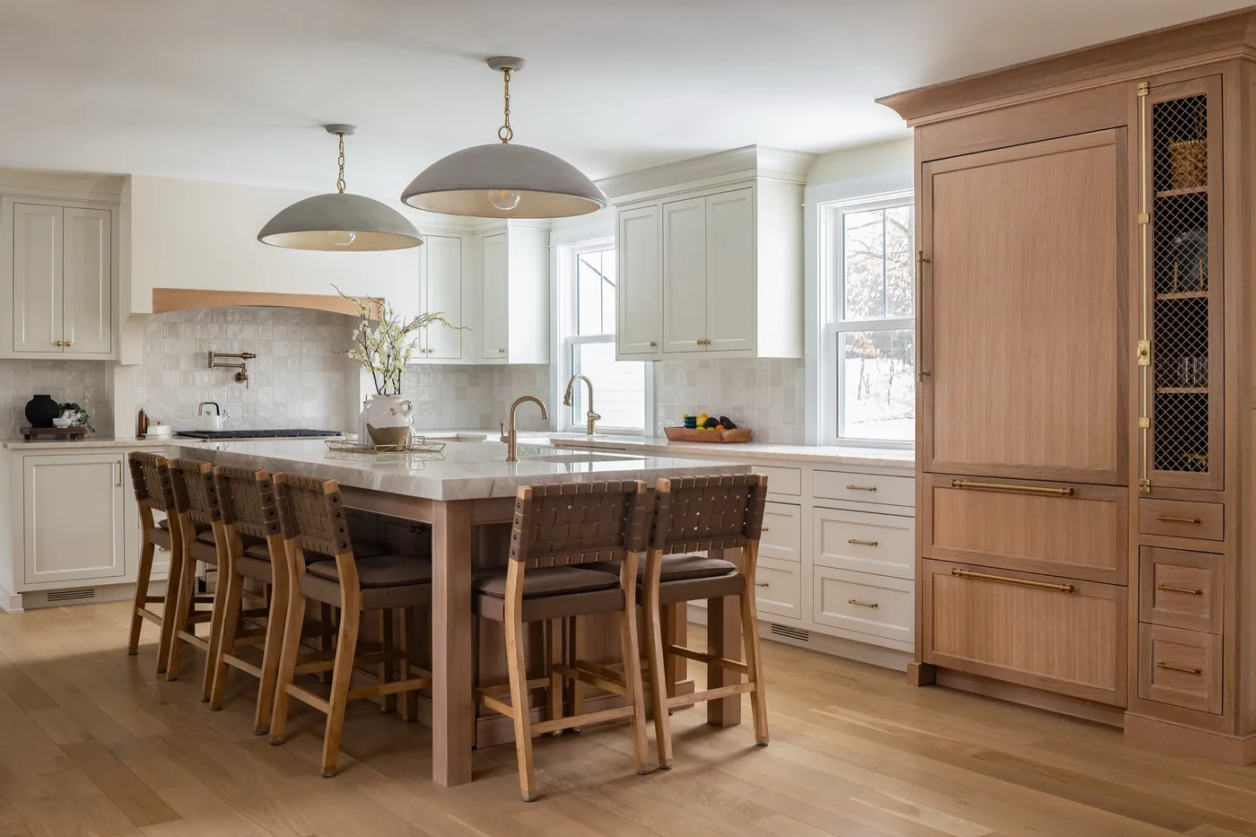 White oak kitchen island with a paneled refrigerator wall